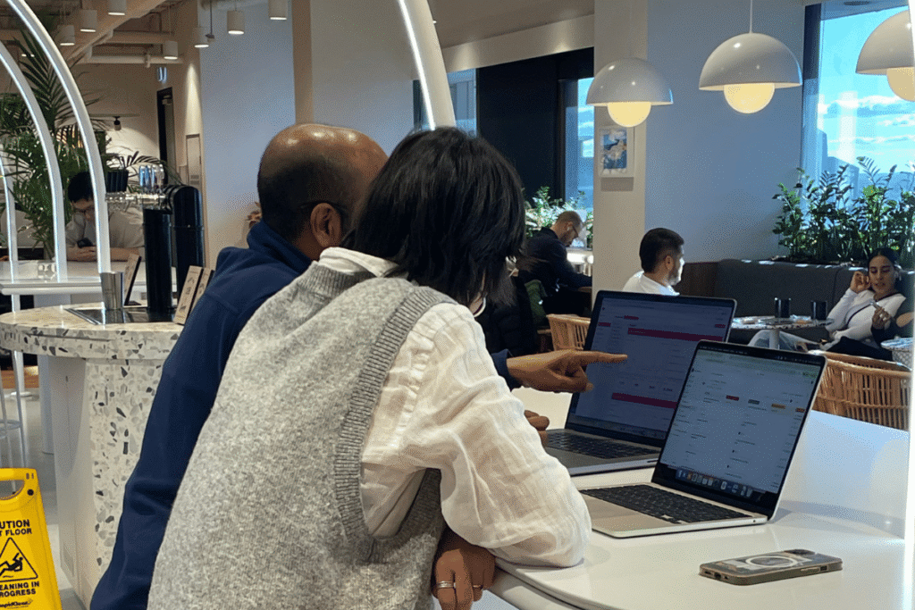 Two people looking at laptop screens